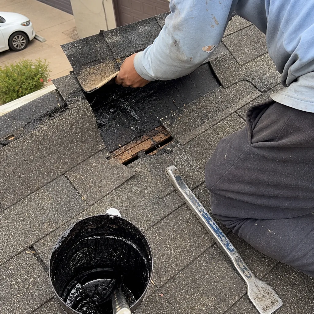 Professional roofer performing shingle repair on a residential roof